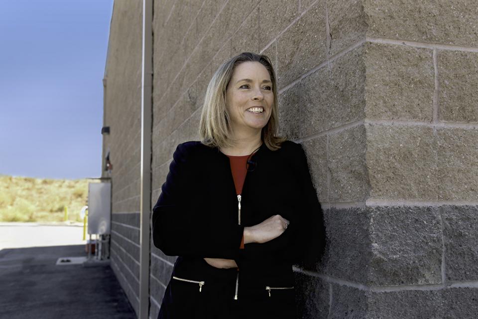 alerie Pryor, Zone 7 Water Agency's General Manager, leaning against wall with arms crossed and smiling
