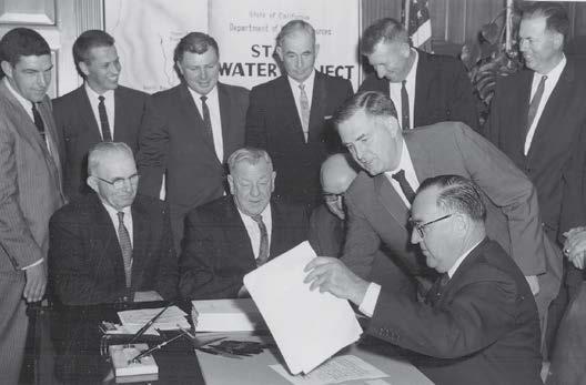 8 men in suits gathered around a table, 1961