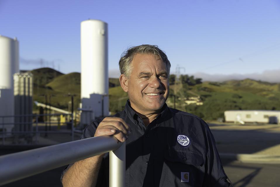 Male employee standing in front of water treatment plant
