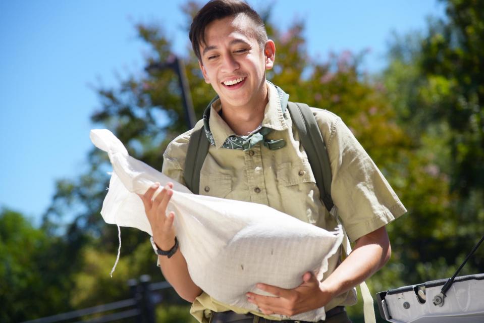 Flood Ready Freddy holding a white sandbag