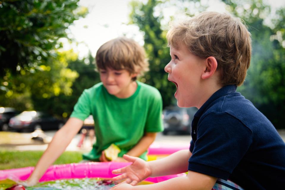 Two boys smiling while playing in water