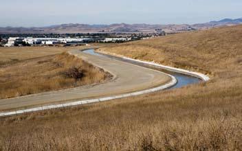 South Bay Aqueduct surrounded by valley grass and City skyline in the background