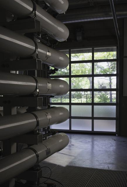 5 white pipes lined against a wall, used for reverse osmosis